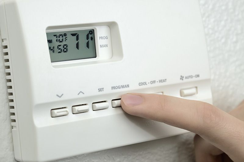 Person adjusting their air conditioner system