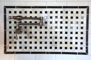 Image of a pot water filler mounted on a wall over a stove