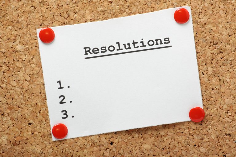 Paper pinned to a cork board showing resolutions 