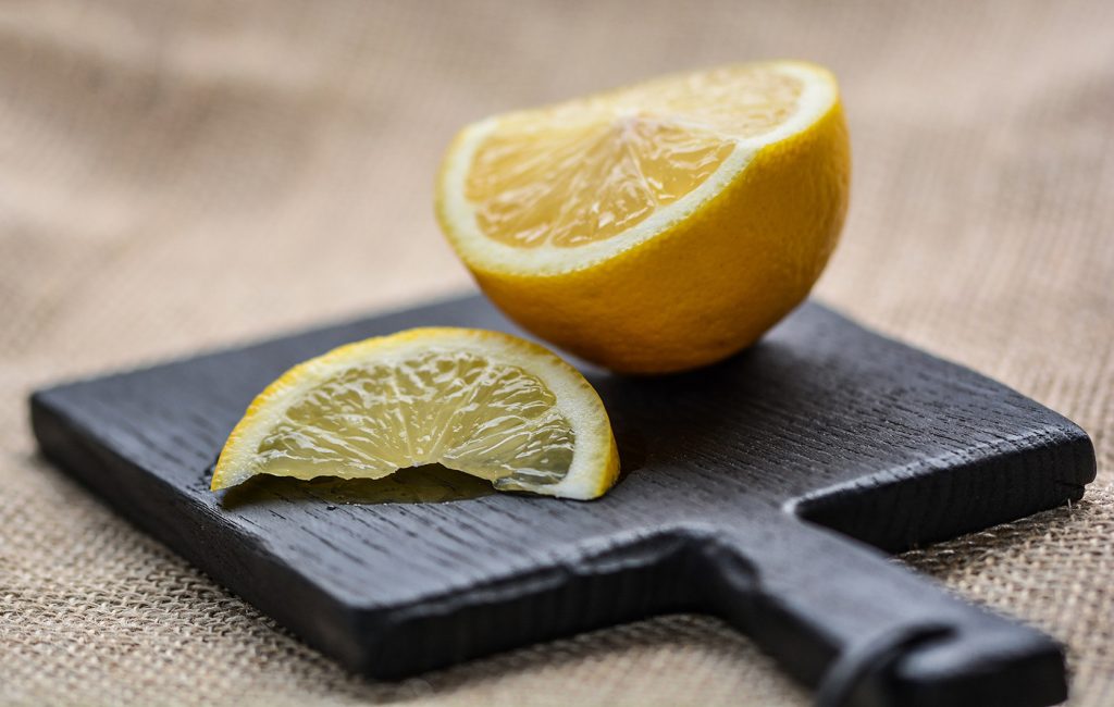 a lemon cut into pieces on a cutting board