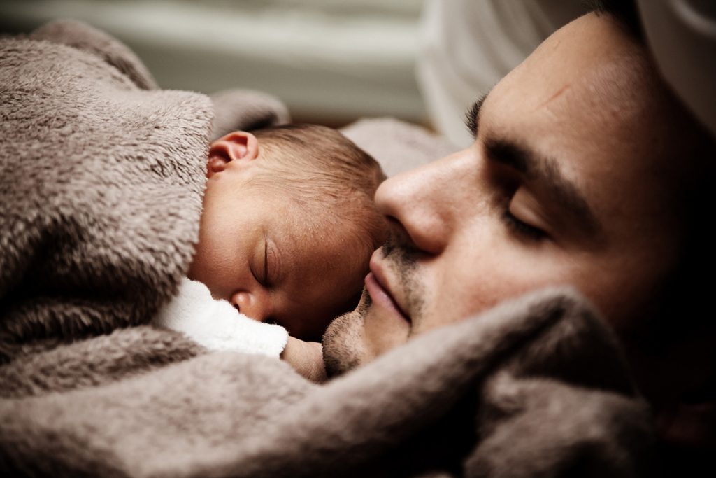 Man sleeping with a baby laying on his chest 