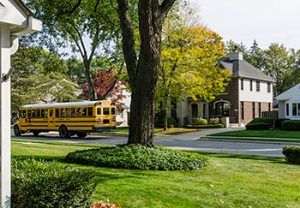 Nice neighborhood with a school bus driving by 
