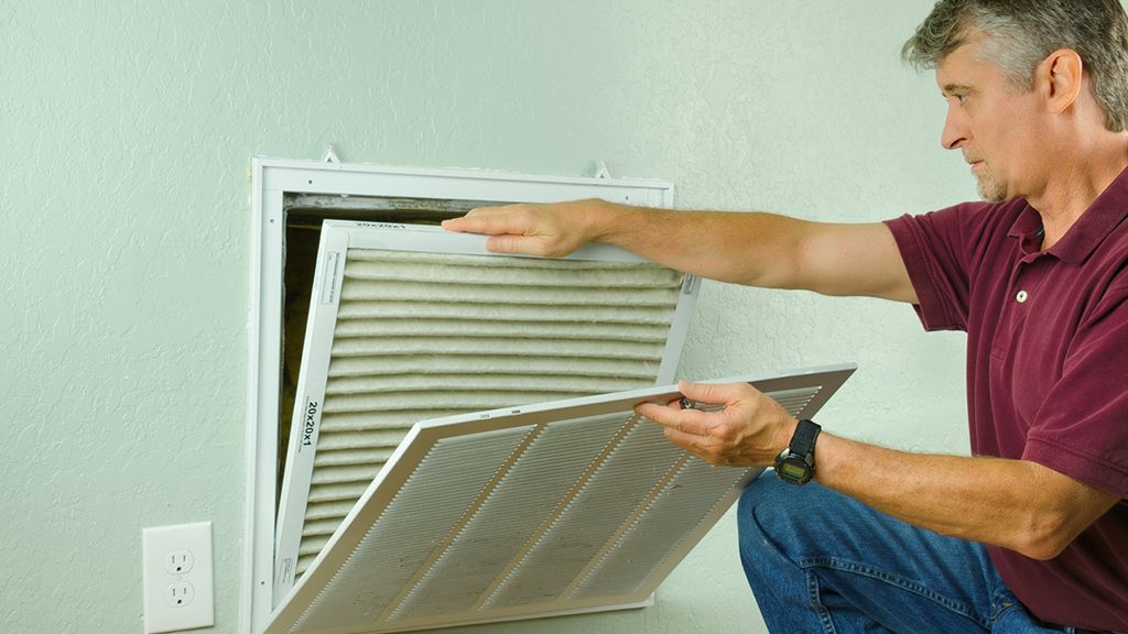 Person inspecting a ventilation system 