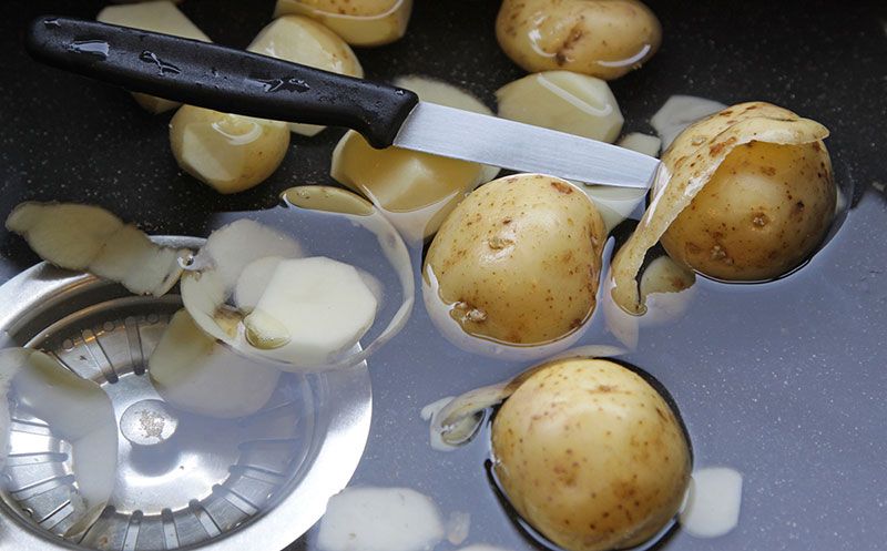 peeled potatoes floating in a sink