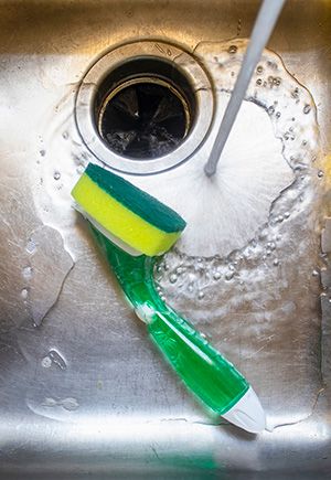 Kitchen sink with a sponge and running water